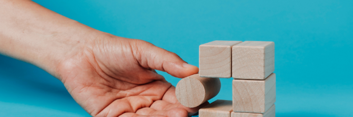Titel: Strategische Problemlösung in der IT-Beratung

Beschreibung: Eine Hand platziert einen runden Holzblock in einen Würfel aus Holzklötzen, der vor einem hellblauen Hintergrund steht. Dieses Bild symbolisiert innovative Problemlösungen in einer IT-Age