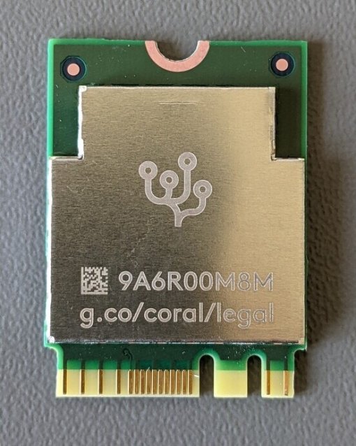 Modul mit silberner Abdeckung auf grüner Platine, QR-Code und Link zu g.co/coral/legal unterhalb eines stilisierten Logos.