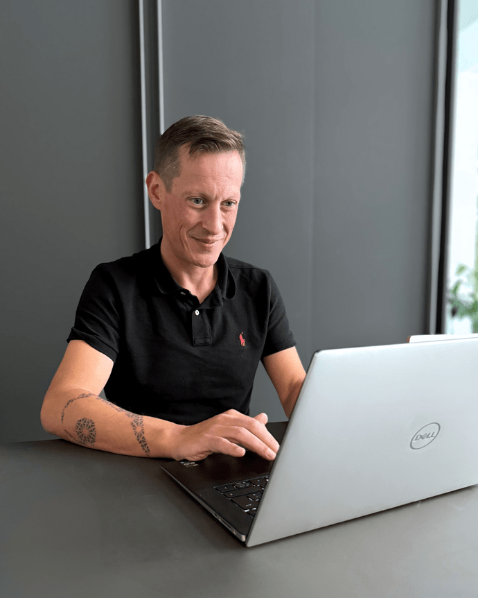 Person am Laptop in einem modernen Büro, konzentriert arbeitend.