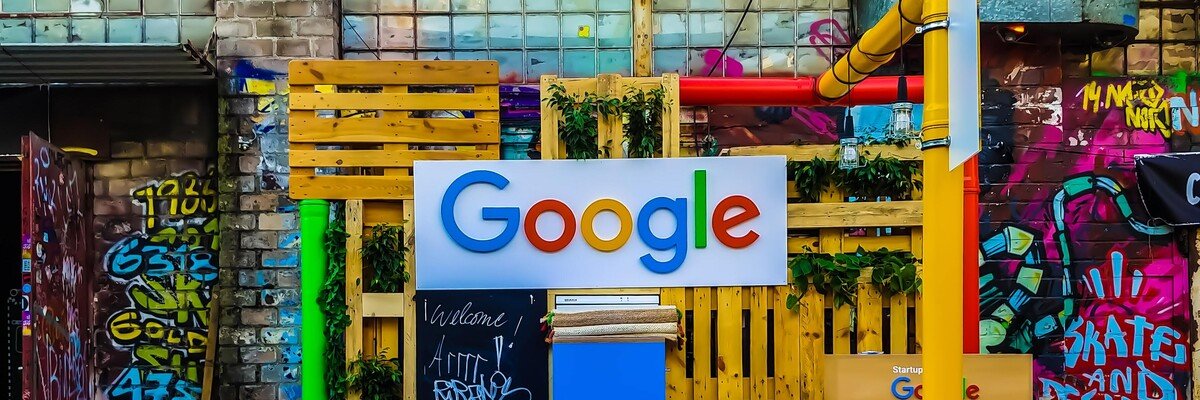 Bunter Google-Stand aus Paletten mit Graffiti-Hintergrund und Pflanzen, dekorativ und kreativ gestaltet.