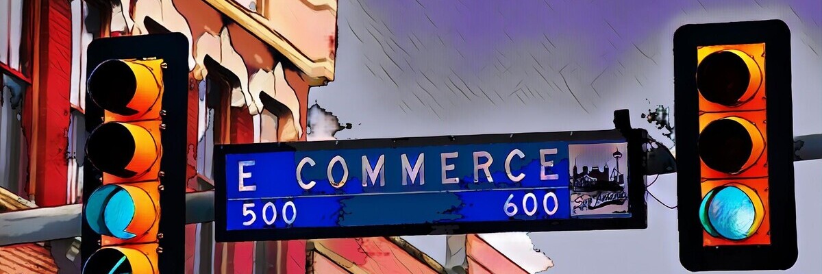 Straßenschild mit der Aufschrift "E Commerce" und Leuchtsignalen vor städtischer Architektur im Hintergrund.