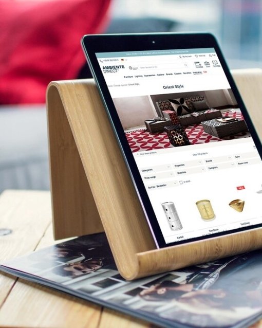Tablet auf Holzständer mit Wohnzeitschrift in Luxuseinrichtung nutzen.